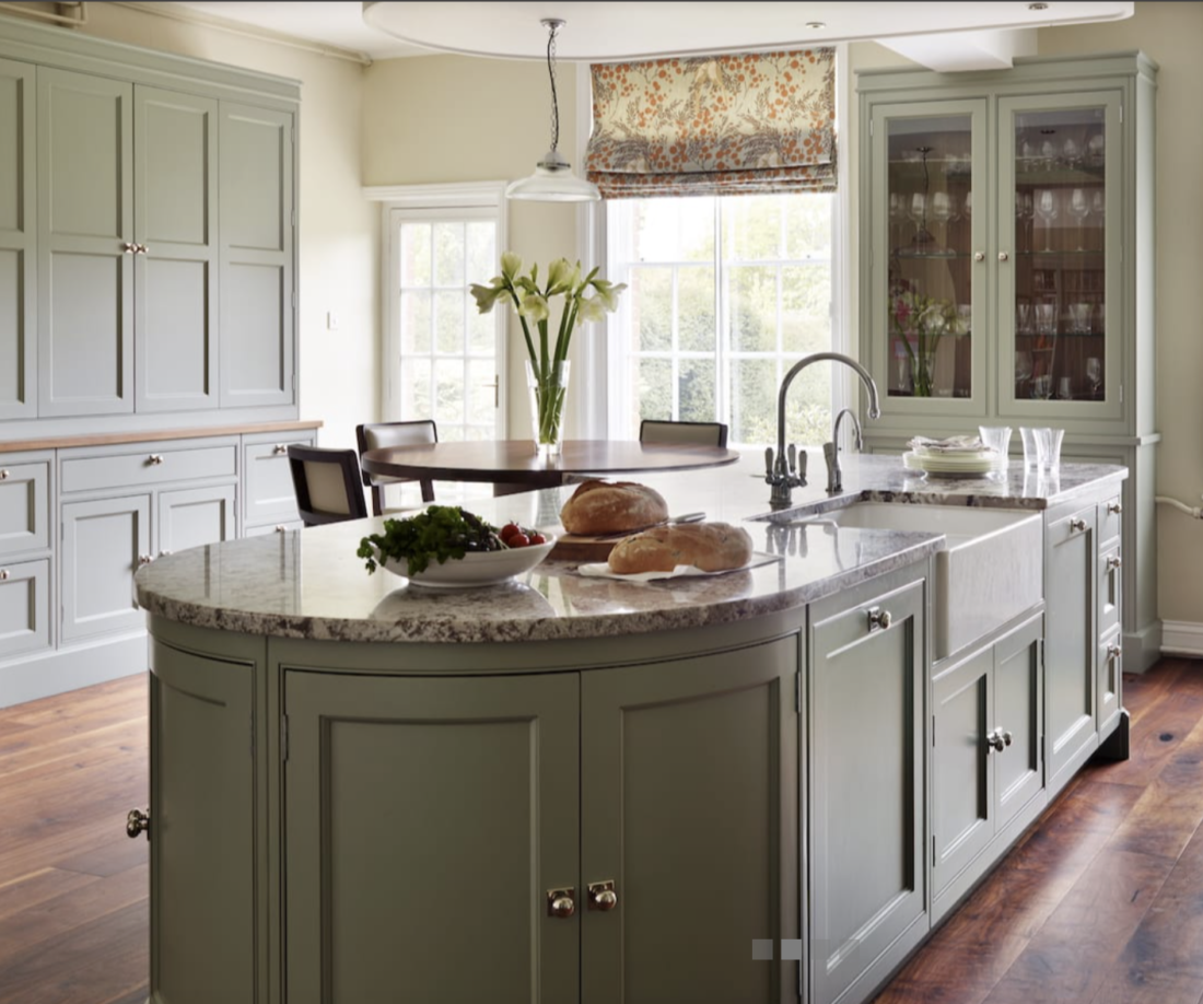 Traditional kitchen with sage green cabinets and curved island